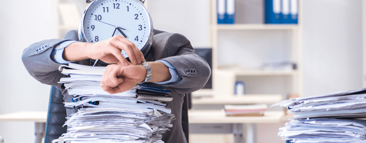 Male behind a pile of work