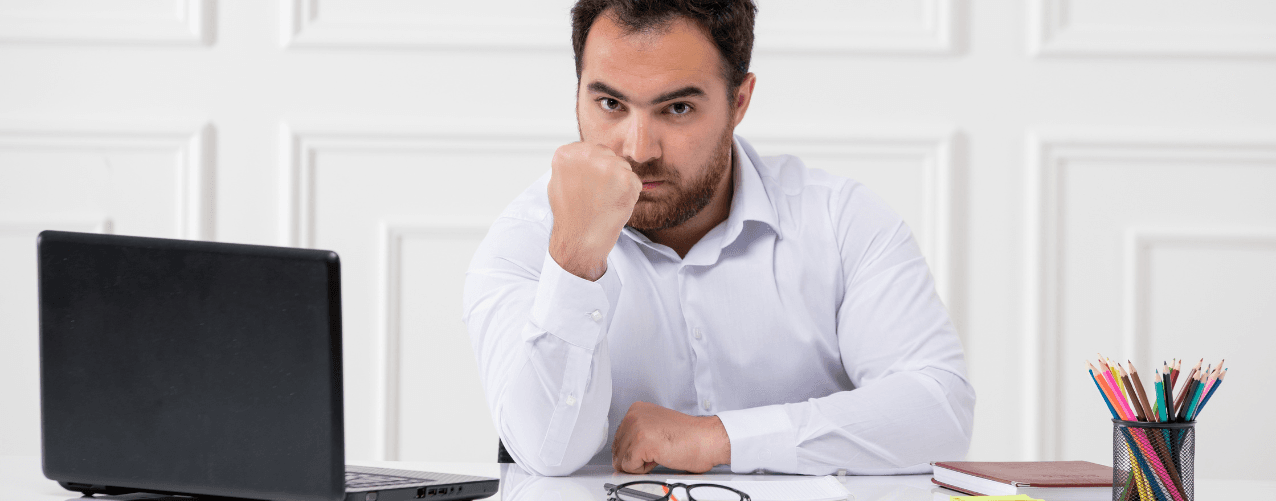 Male sat at desk looking angry