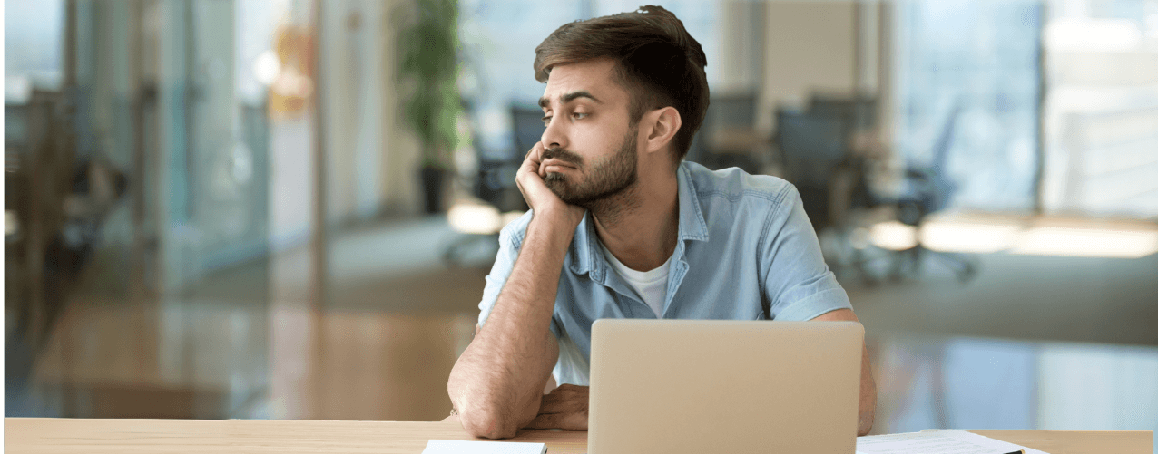 Male at a computer holding face