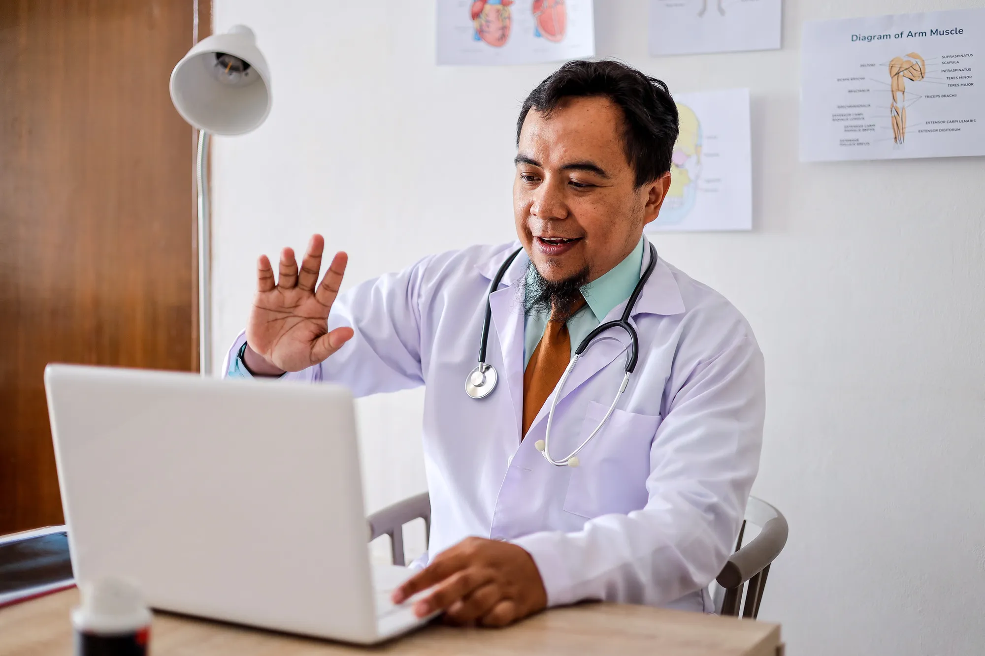 Doctor waving at computer